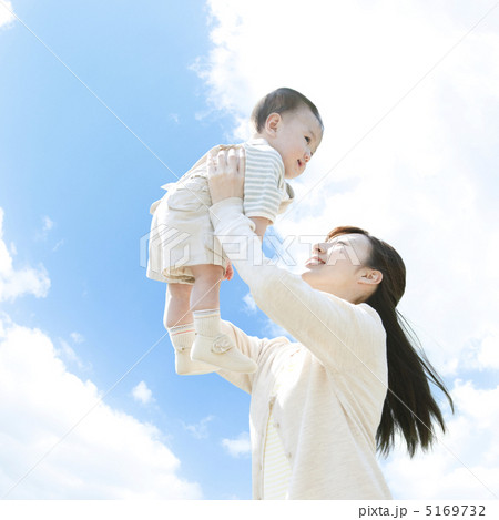 赤ちゃんを抱き上げる母親の写真素材