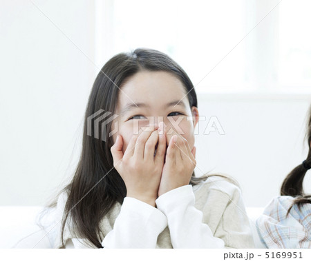口元に手を当てて笑う女の子の写真素材