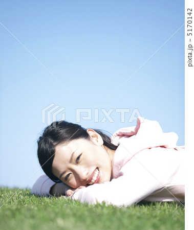 草原にうつ伏せに寝転ぶ女性 5170142
