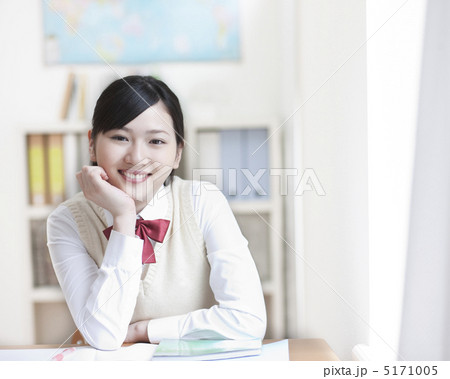 頬杖をついて笑う女子高生の写真素材