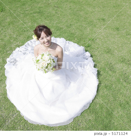 ブーケを持って草原に座る新婦 5171124