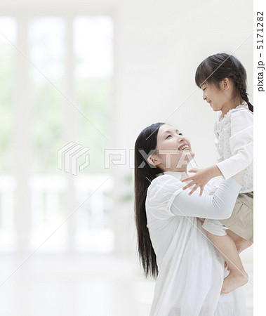 娘を抱き上げる母親の写真素材