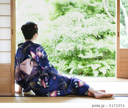 障子にもたれて座る浴衣姿の女性の後ろ姿の写真素材
