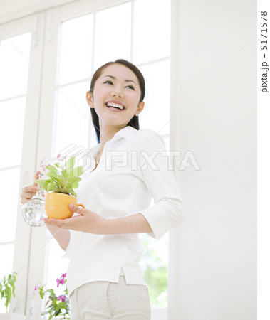 鉢植えの花を持つ女性の写真素材