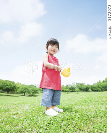 草原でじょうろを持つ女の子 5172072