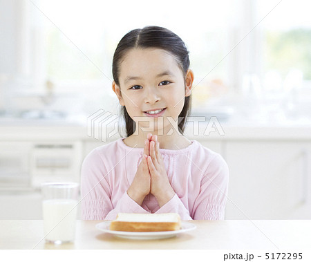食卓で手を合わせる女の子の写真素材