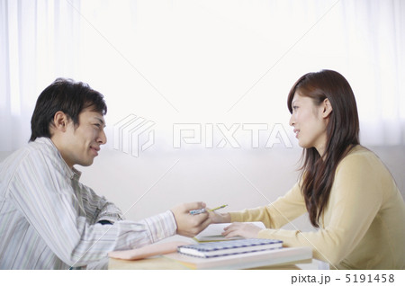 テーブルをはさんで見つめ合う男女 5191458