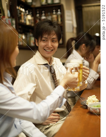 居酒屋のカウンターで乾杯をするカップル 5191522
