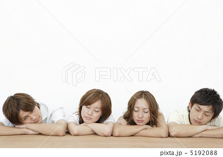 組んだ腕に顎を乗せてうたた寝する若者達の写真素材 519