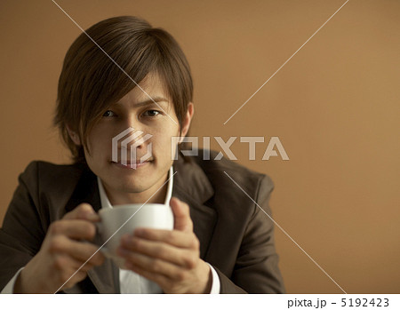 コーヒーカップを持つ男性の写真素材