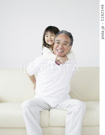 ソファの上で祖父にしがみつく孫 5192549