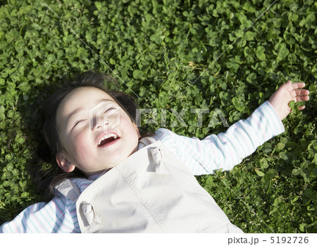 草の上で気持ちよさそうに寝転ぶ女の子 5192726