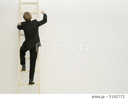 はしごに登る男性の後ろ姿の写真素材