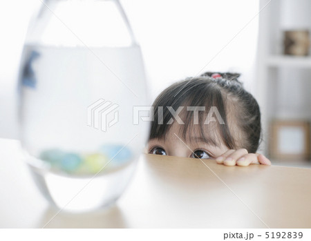 水に入ったビー玉をテーブルの下から見ている女の子 5192839