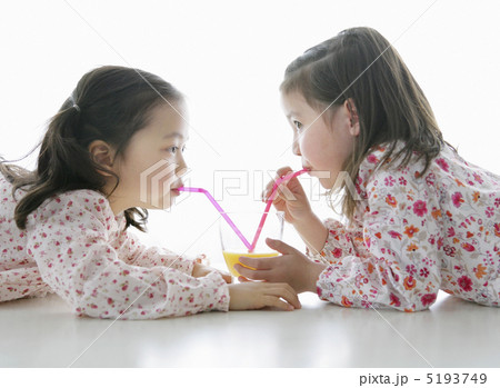 向かい合ってストローでジュースを飲む女の子 5193749