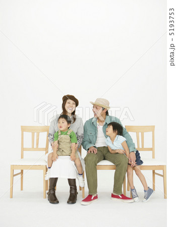 ベンチに腰掛け寛ぐ若い夫婦と二人の子供 5193753