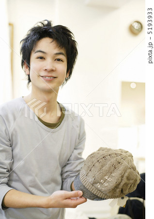 ニットキャップを手にして微笑む若い男性 5193933