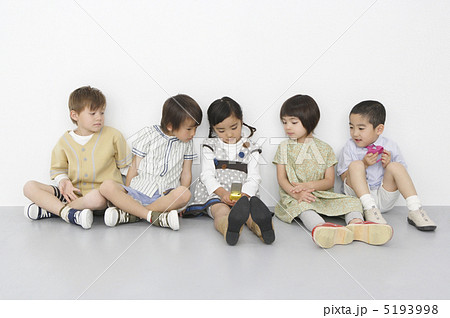 携帯電話を覗き込む子供達 携帯電話を覗き込む子供達 5193998