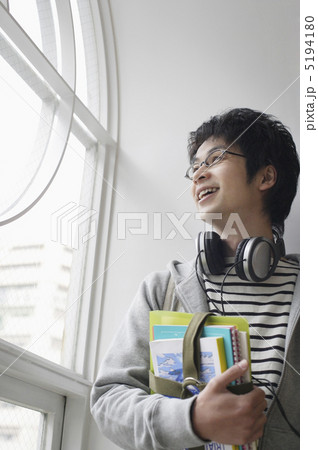 ヘッドフォンを首にかけ本を抱えた若者 ヘッドフォンを首にかけ本を抱えた若者 5194180