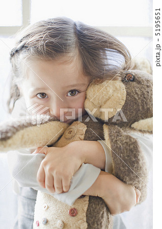 ぬいぐるみを抱きしめる女の子の写真素材