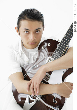 ギターを抱きかかえる男性の写真素材