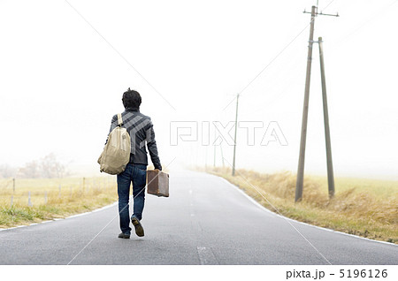道を歩く男性の後ろ姿の写真素材