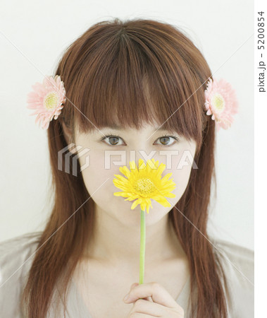 ガーベラの花を持った日本人女性の写真素材