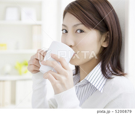 コーヒーカップで飲む日本人女性の写真素材