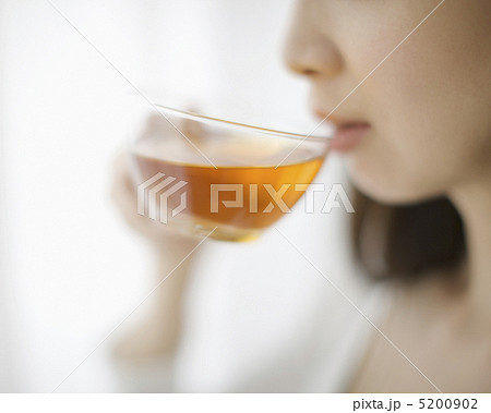 紅茶を飲む女性の口元の写真素材