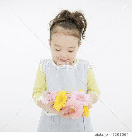 両手いっぱいの花を見つめる女の子の写真素材