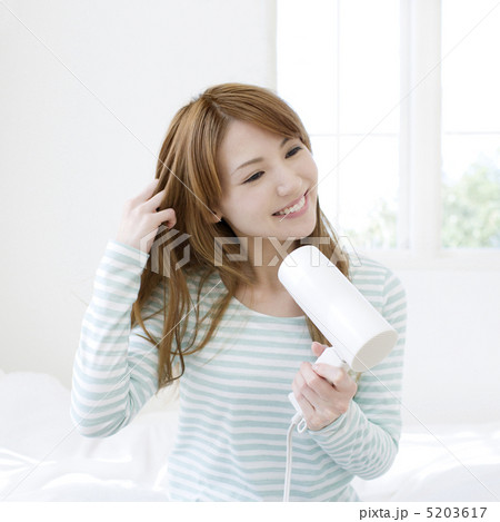 ドライヤーで髪を乾かす女性 5203617