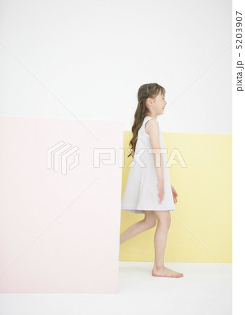 薄ピンクと黄色のマットの前を横切る女の子 5203907