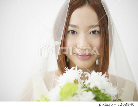 花を持つウェディングドレス姿の女性 花を持つウェディングドレス姿の女性 5203940