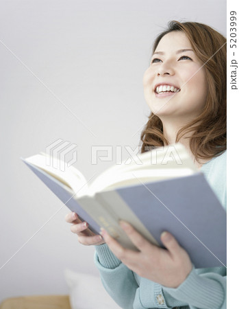 ベッドに座って微笑む女性 5203999