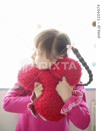クッションを抱きしめる女の子の写真素材