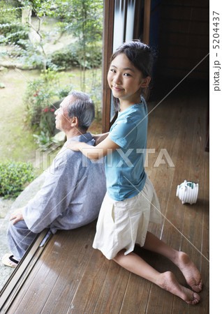 縁側で祖父の肩を揉む孫 5204437