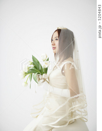 花を持つウェディングドレス姿の女性 5204843