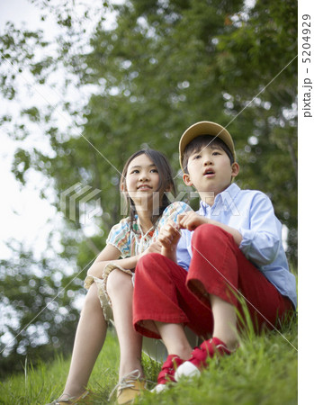 土手に座る男の子と女の子 5204929