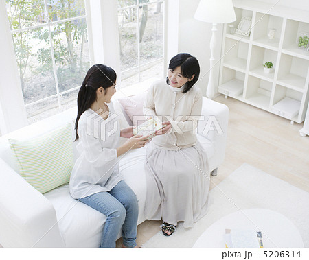 母にプレゼントを手渡す娘 5206314