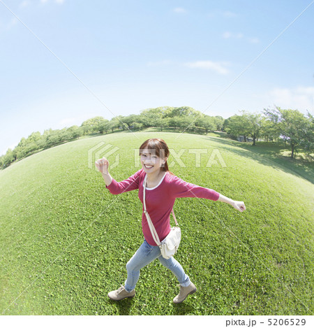 草原を歩く笑顔の女性 5206529
