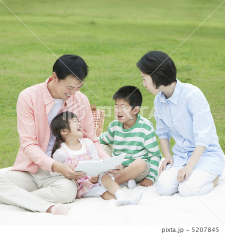 シートに座って本を読む笑顔の家族 5207845