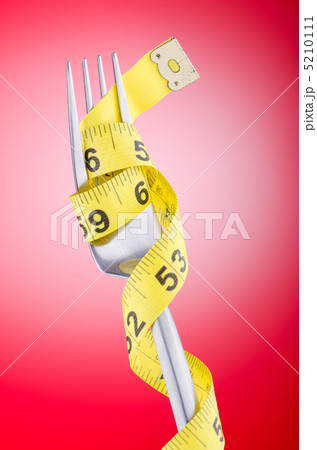 Dieting concept with fork and meter 5210111