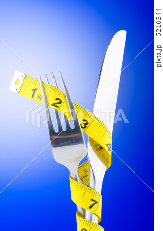 Dieting concept with fork and meter Dieting concept with fork and meter 5210344