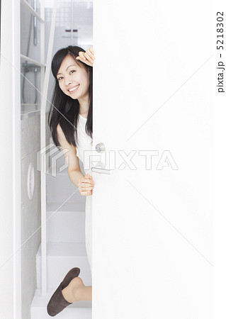 ドアから覗く女性の写真素材