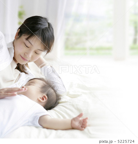 眠る赤ちゃんに添い寝する母親 5225724