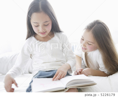 ベッドの上で本を読む二人の少女 5226179