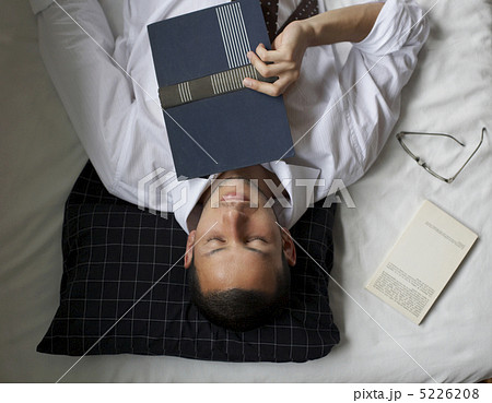 仰向けに眠る男性の写真素材