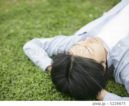 仰向けに寝転ぶ男性の写真素材