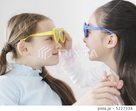 サングラスをかけて見つめ合う二人の少女 5227338