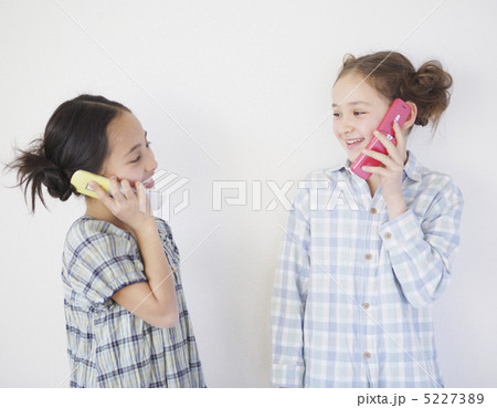 携帯電話で会話する二人の少女 5227389